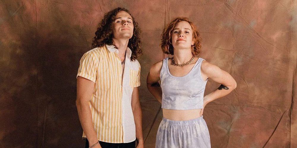 a man and woman with a sky background