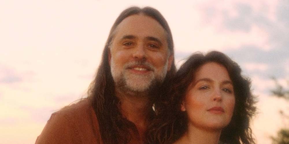 a man and woman with a sky background
